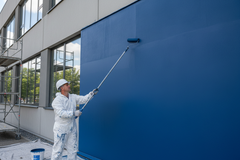 Pintor a aplicar tinta EVERESTE Dissoltin com rolo de fachada em parede exterior